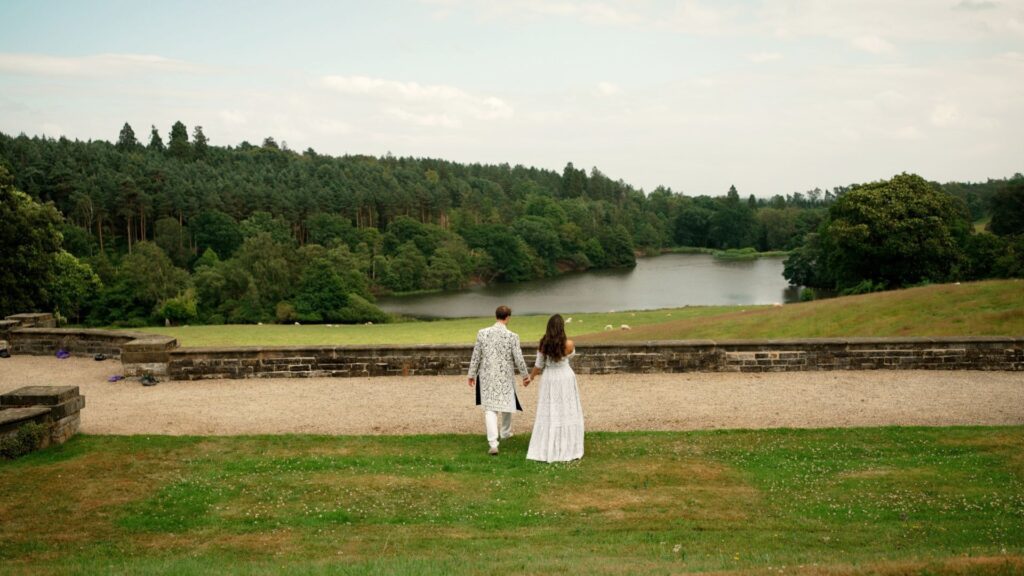 a bride and groom walking to a lake in Osmaston Park at their wedding
